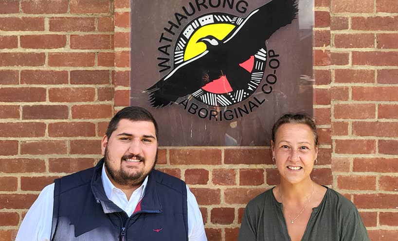 Lawyer John Cattanach and Aboriginal Community Engagement Officer Belinda Foley sitting in front of brown brick wall